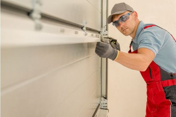Technician adjusting torsion spring system