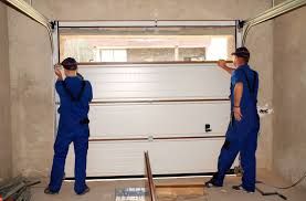 Two technicians installing a new garage door